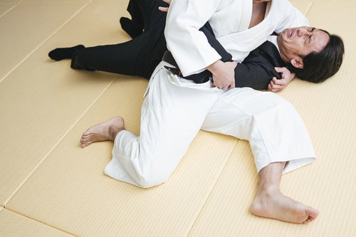 袈裟固めをかけられる柔道の男性選手の寝技