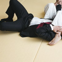 スーツ姿でギブアップする腕ひしぎ十字固めの写真