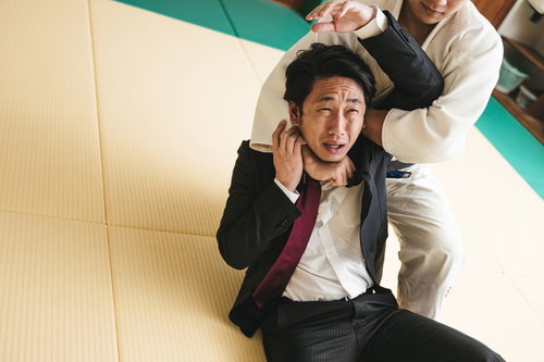 道場で片羽絞めをかけられる会社員