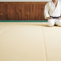 柔道場の畳で白い道着姿のまま静かに正座する選手の写真