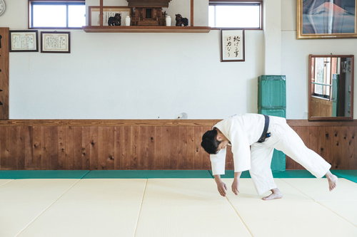 柔道の前回り受け身を実演する男性選手の稽古風景