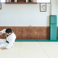 柔道の前回り受け身を練習する男性の基本動作の写真