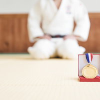 柔道場の畳に置かれた金メダルの写真