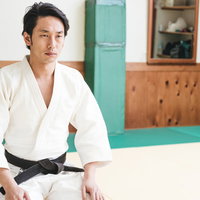 正座して試合を見守る柔道の有段者（黒帯）の写真