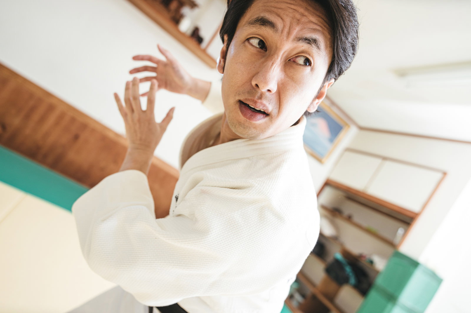 白い柔道着を着た男性が必殺技のポーズを決めている様子［モデル：大川竜弥］