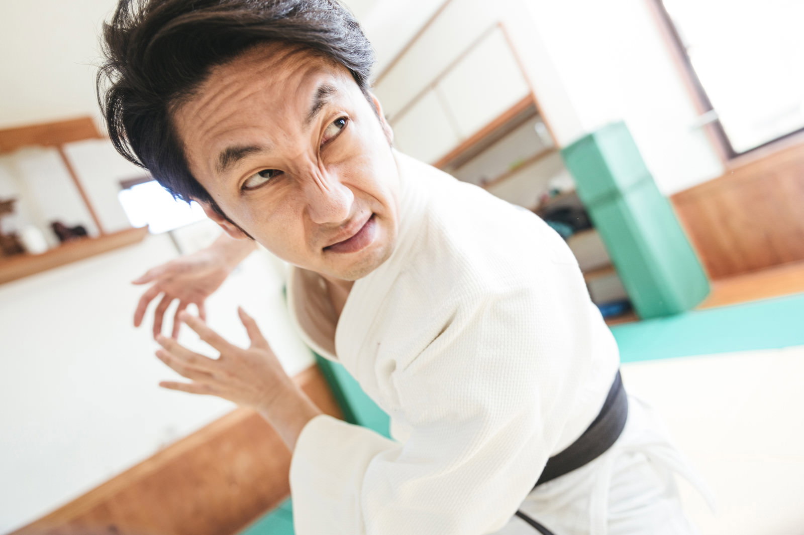 柔道着を着た男性が手を前に出して制止するポーズをしている［モデル：大川竜弥］