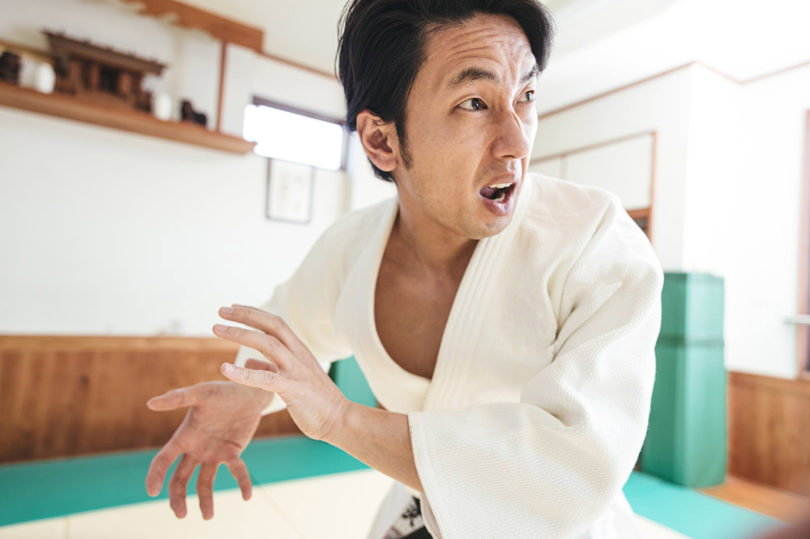 白い柔道着を着た男性が必殺技のポーズを取っている［モデル：大川竜弥］