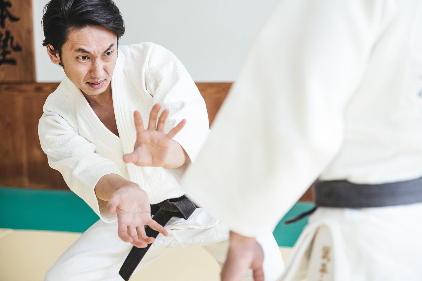 白い柔道着を着た男性が畳の上で念動力を使おうとしている［モデル：大川竜弥］
