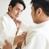 お互いの襟を掴む柔道試合の組み手。畳の上での真剣な対戦風景の写真