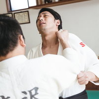 柔道の組み手を練習する男性たちの競技風景の写真