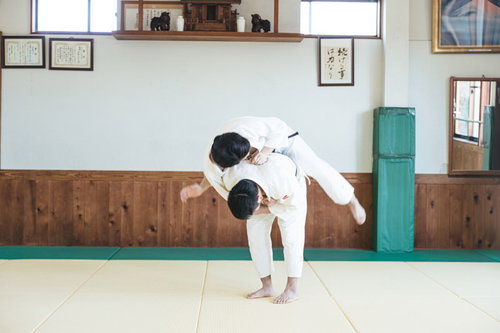柔道の投げ技 一本背負いを道場で実演する男性