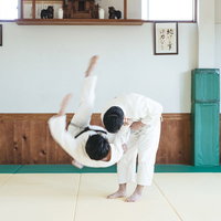 柔道の投げ技一本背負いを決める瞬間。道場での稽古風景の写真