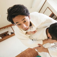 背負投で投げられる瞬間の柔道男性選手の競技風景の写真