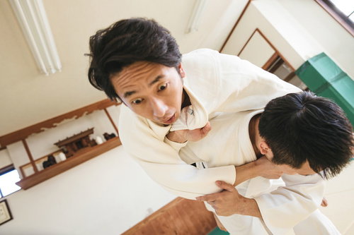 背負投で投げられる瞬間の柔道男性選手の競技風景
