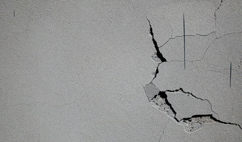 白い石膏ボードに走る亀裂とひび割れ、壁の経年劣化クラック