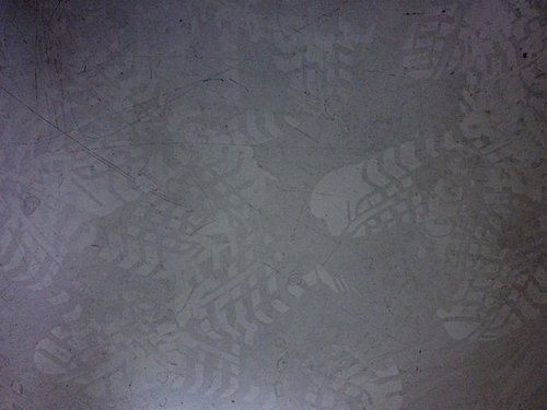 床に付いた無数の足跡が重なるグレーのテクスチャ