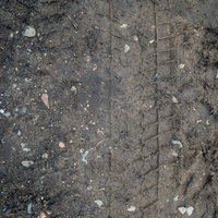 泥道の地面に残ったタイヤの跡と轍の痕跡と車両通過跡の写真