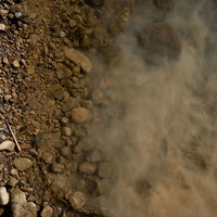 浅瀬の濁った水面のテクスチャー：川底の砂利と泥が舞い上がる自然の写真