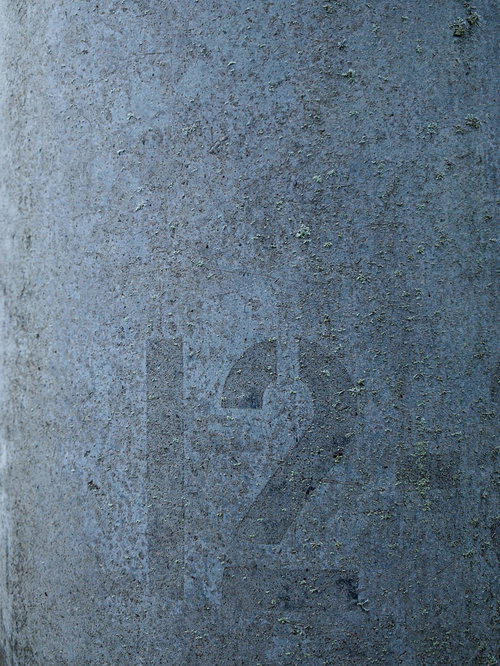 電柱に刻まれた12番の跡が付いたコンクリート