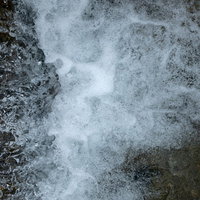 岩にぶつかり勢いで泡となる水面、清流の躍動感の写真