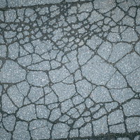 ヒビだらけのアスファルト地面のテクスチャの写真