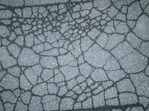 ヒビだらけのアスファルト地面のテクスチャ