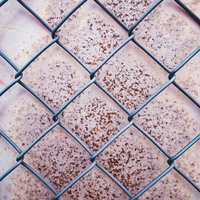 錆付いた金属板と黒い金網フェンスのテクスチャーの写真