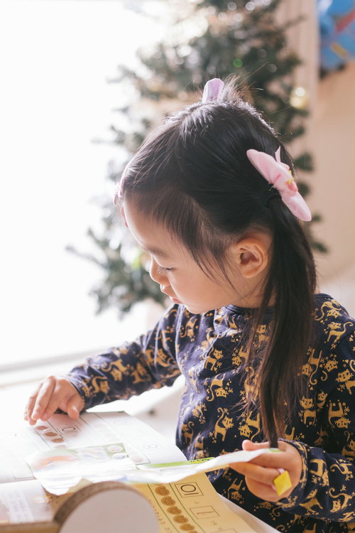 勉強中の愛娘がノートに鉛筆で書き込む様子