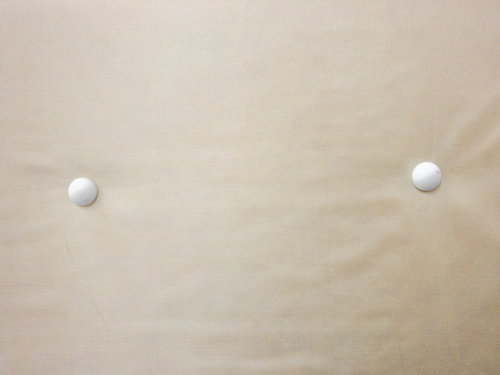 ボタン付きのベージュ色の布テクスチャー