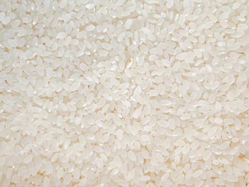 白米に紛れた一粒のテクスチャー、精米された米粒の密集パターン背景