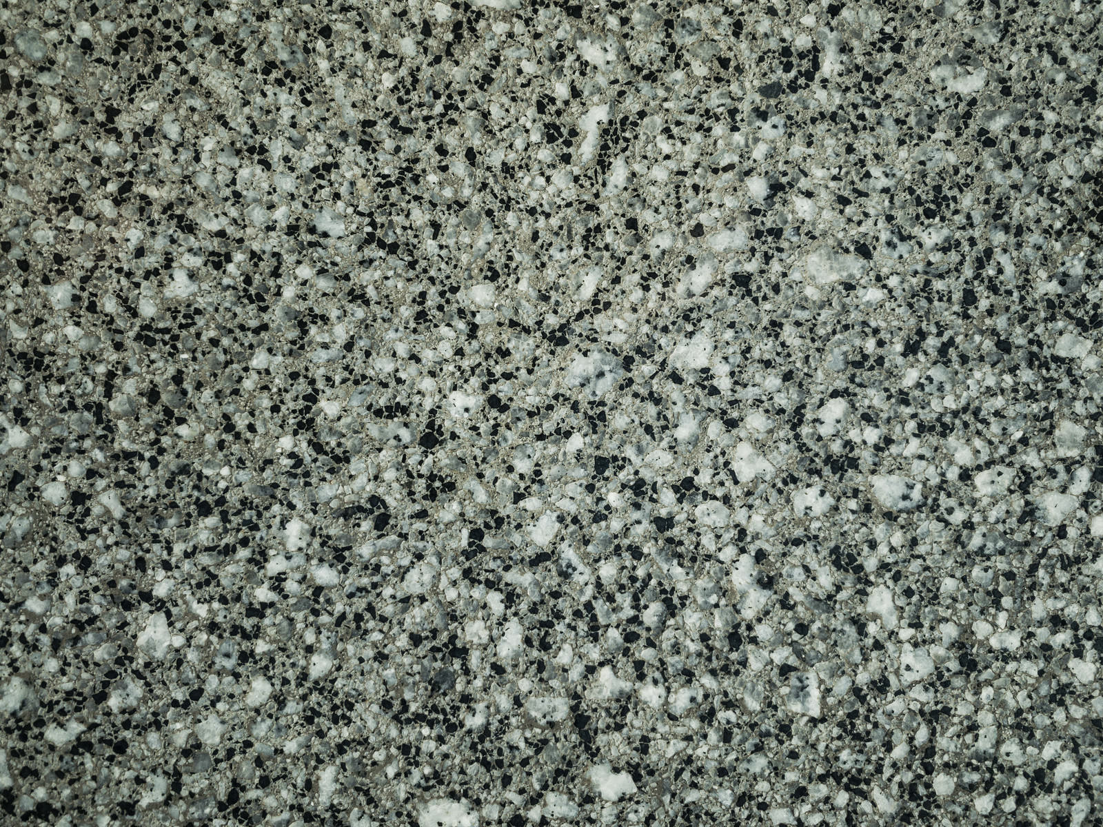灰色ベースに黒と白の粒状模様が分布した花崗岩の表面テクスチャー