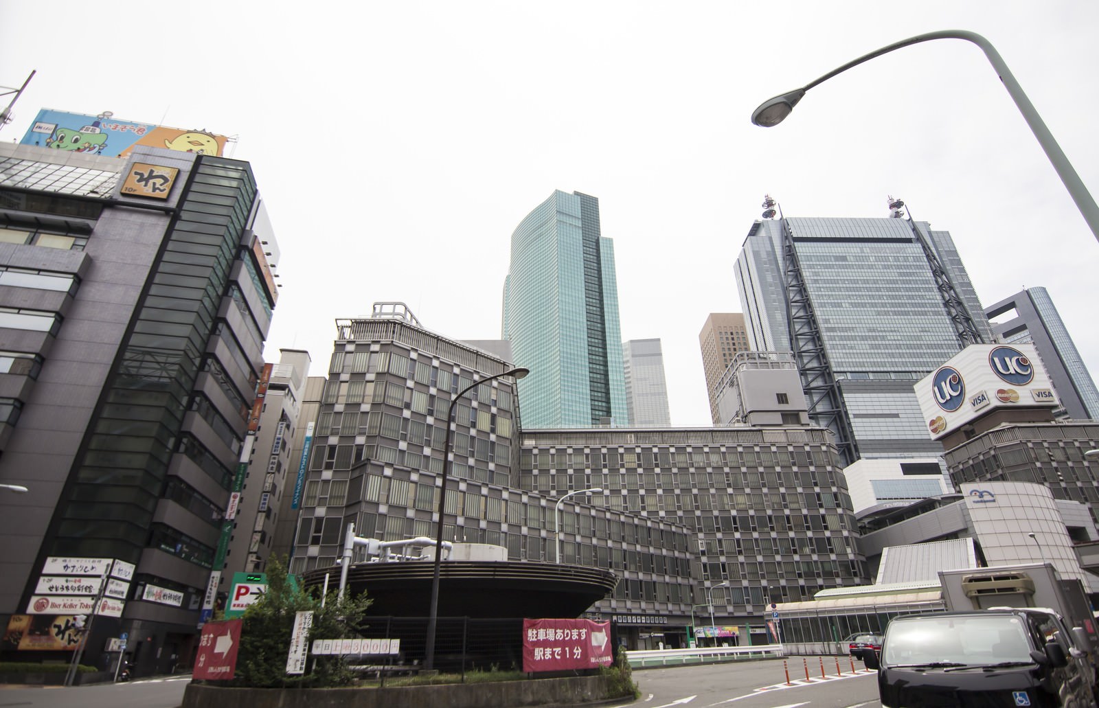 新橋駅前で見上げた商業ビルと高層ビル、曇り空が広がる都市風景