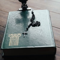 聖書に残る十字架の影とロザリオのチャームの写真
