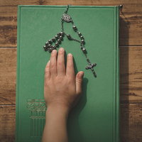 緑色の古書の聖書に手を乗せて行う宣誓式の儀式の写真