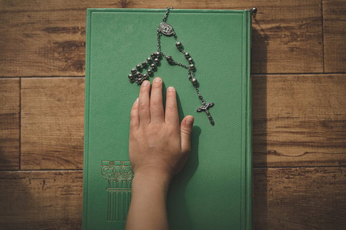 緑色の古書の聖書に手を乗せて行う宣誓式の儀式