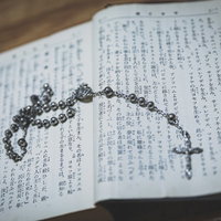 聖書に書かれた言葉とロザリオの写真