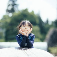 川遊びで冷えた体を温めるウェットスーツ姿の女の子の写真
