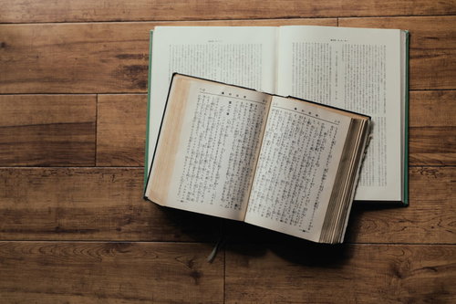 木製テーブルに開かれたままの聖書と古書の質感