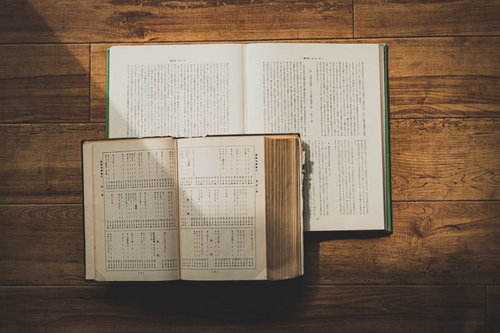 木製テーブルで陽射しを浴びる開かれた聖書
