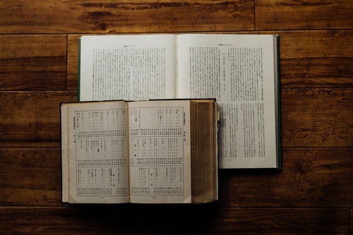 木製テーブルに開かれたキリスト教の教典、複数の聖書
