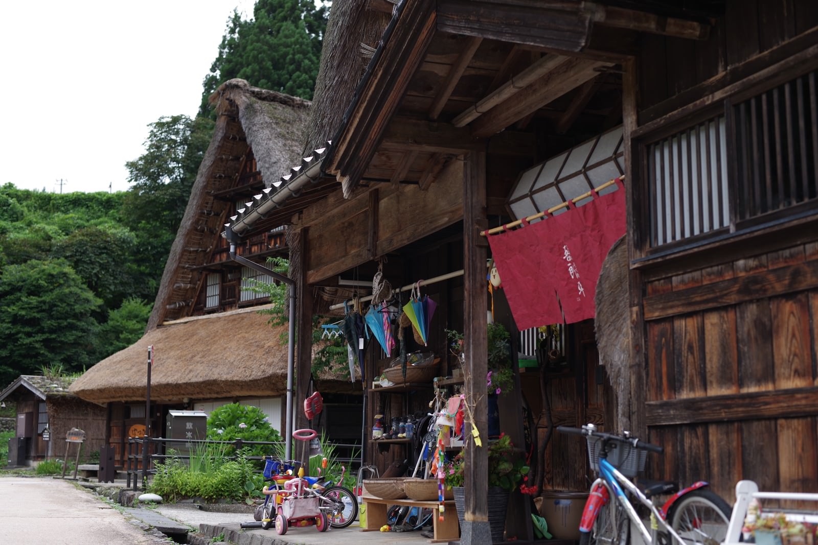 世界遺産菅沼集落の古民家の軒先に赤い暖簾がかかっている風景