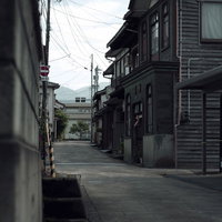 蔵回廊を進んだ先の民家と電柱、石畳の細い路地の写真