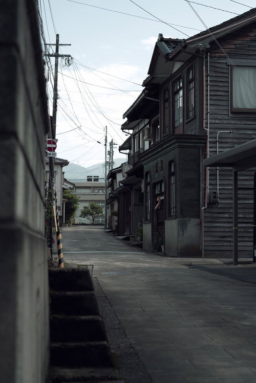 蔵回廊を進んだ先の民家と電柱、石畳の細い路地