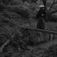 丸太橋で刀を構える黒衣の袴姿侍、川を見張る追手の様相の写真