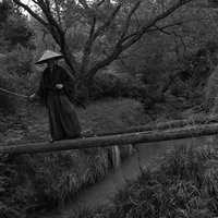 モノクロで撮影した丸太橋の先で待ち構える追手の写真