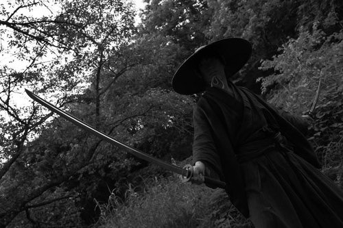 刃先を見据える用心棒の緊迫した立ち姿と日本刀