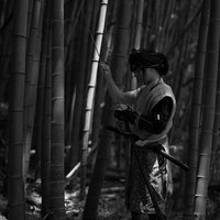 竹林で火縄銃に弾をこめる野盗男性の歴史の写真