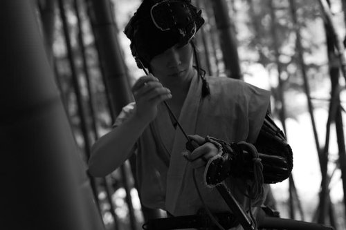 火縄銃に火薬を詰める山賊