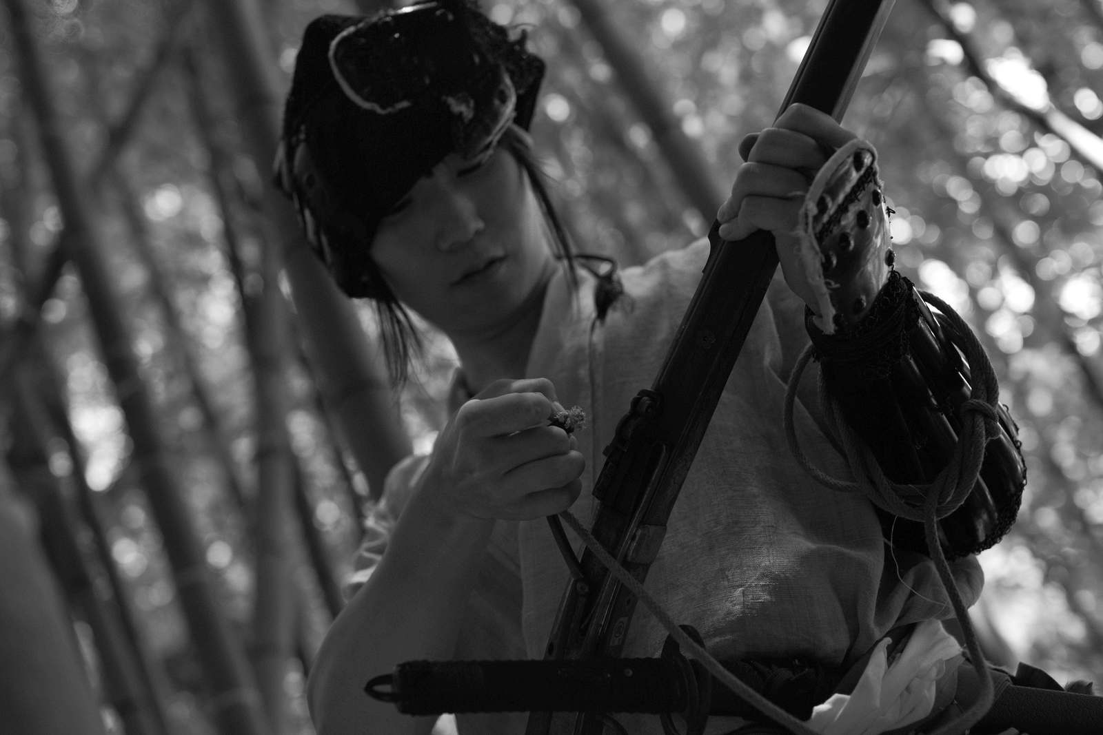 竹林の中で火縄銃を構える野盗姿の男性［モデル：まーこ］