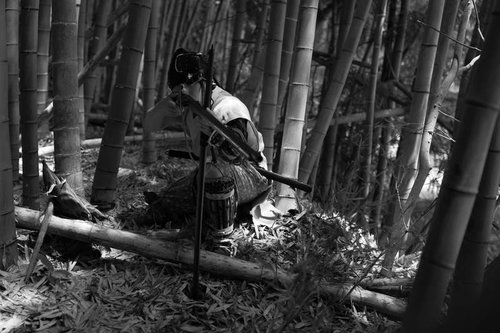 竹林の中で火縄銃を構える山賊の男性